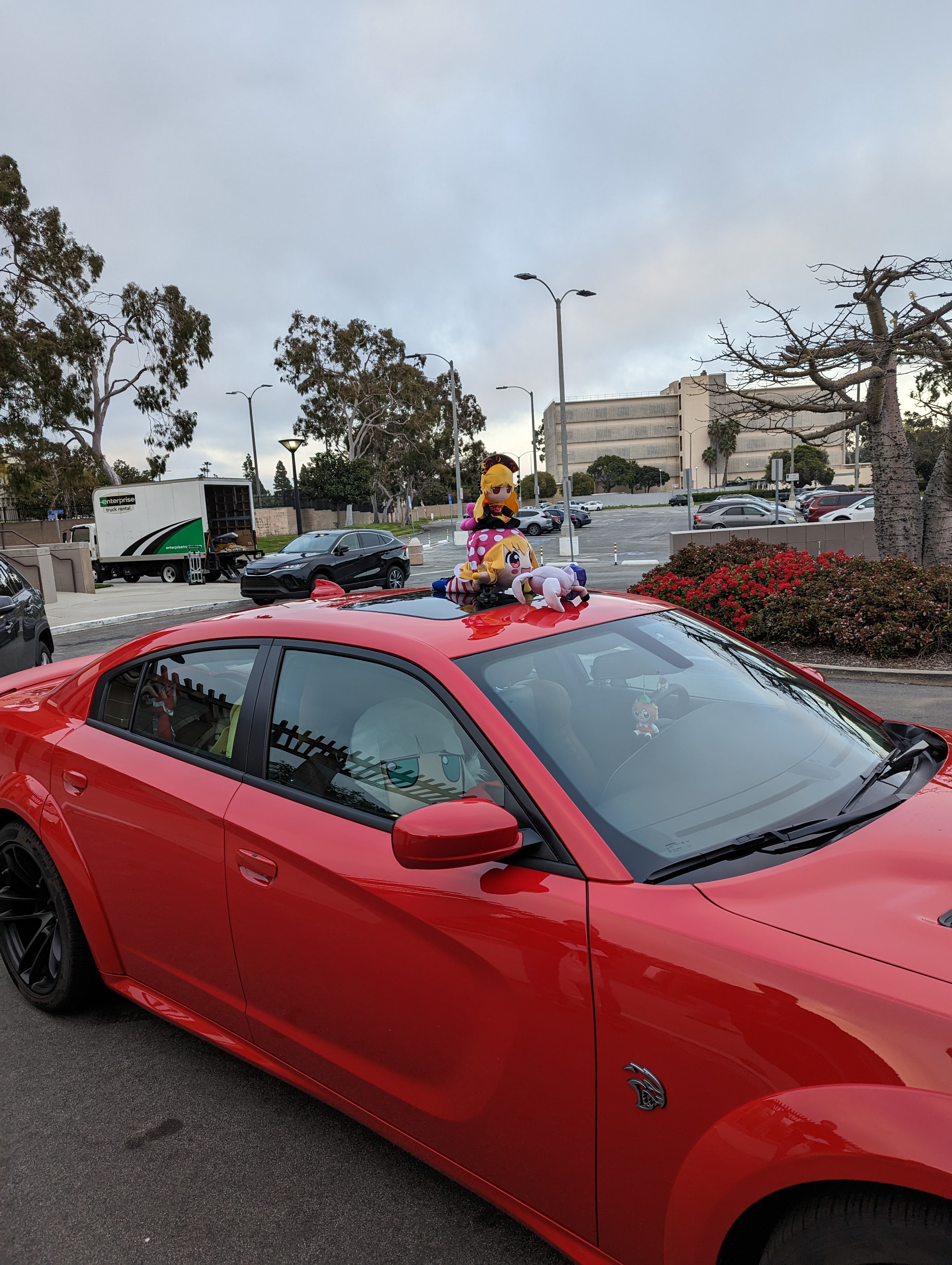 red car with various fumos on top of and inside it