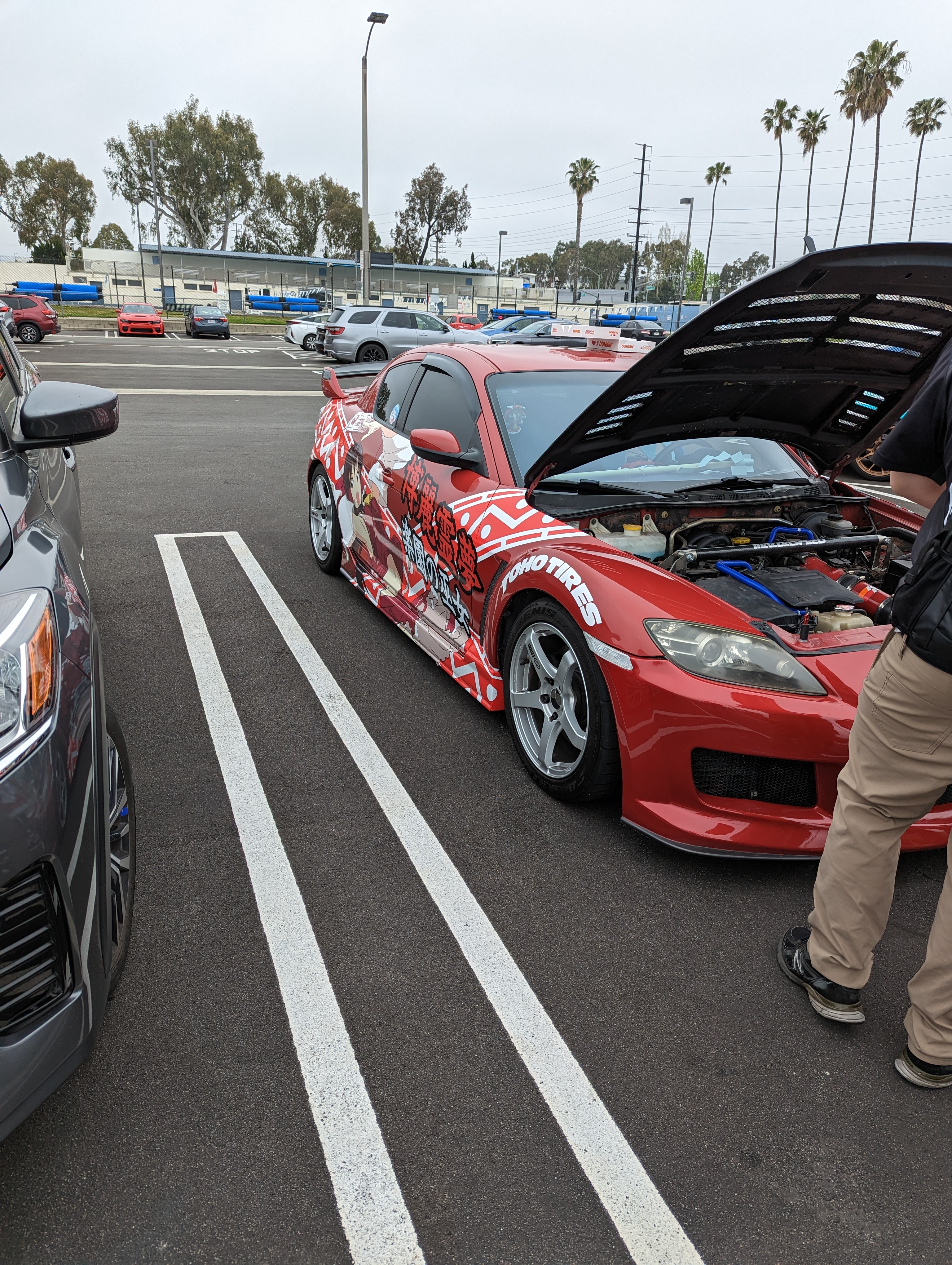 Picture of a red car with fancy Reimu art on the sides